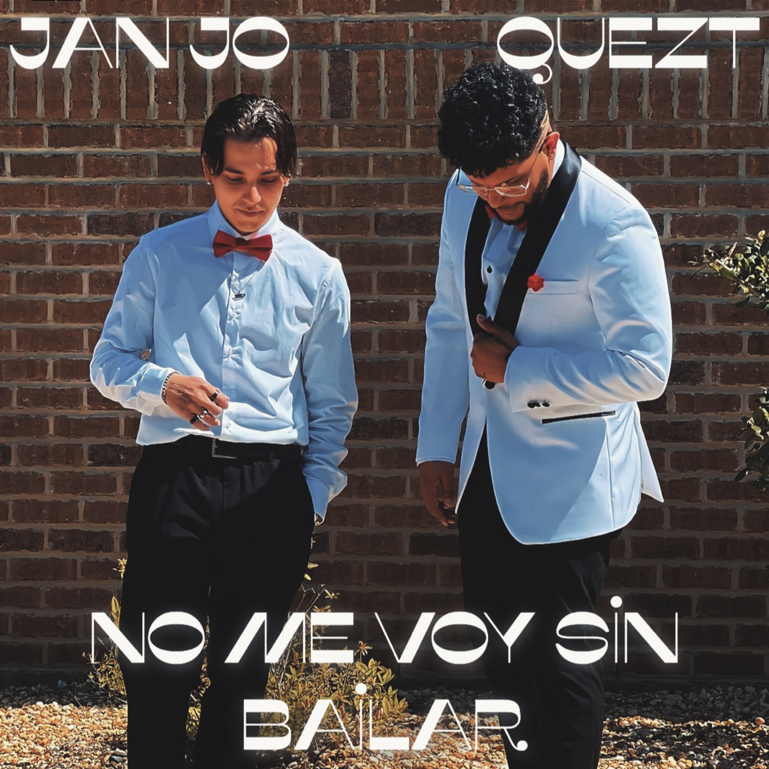 Two men in formal attire standing against a brick wall, one in a white tuxedo with a red bowtie and the other in a white jacket with black trim and glasses, with Spanish text that reads 'Janjo Quezt' and 'No me voy sin bailar'.