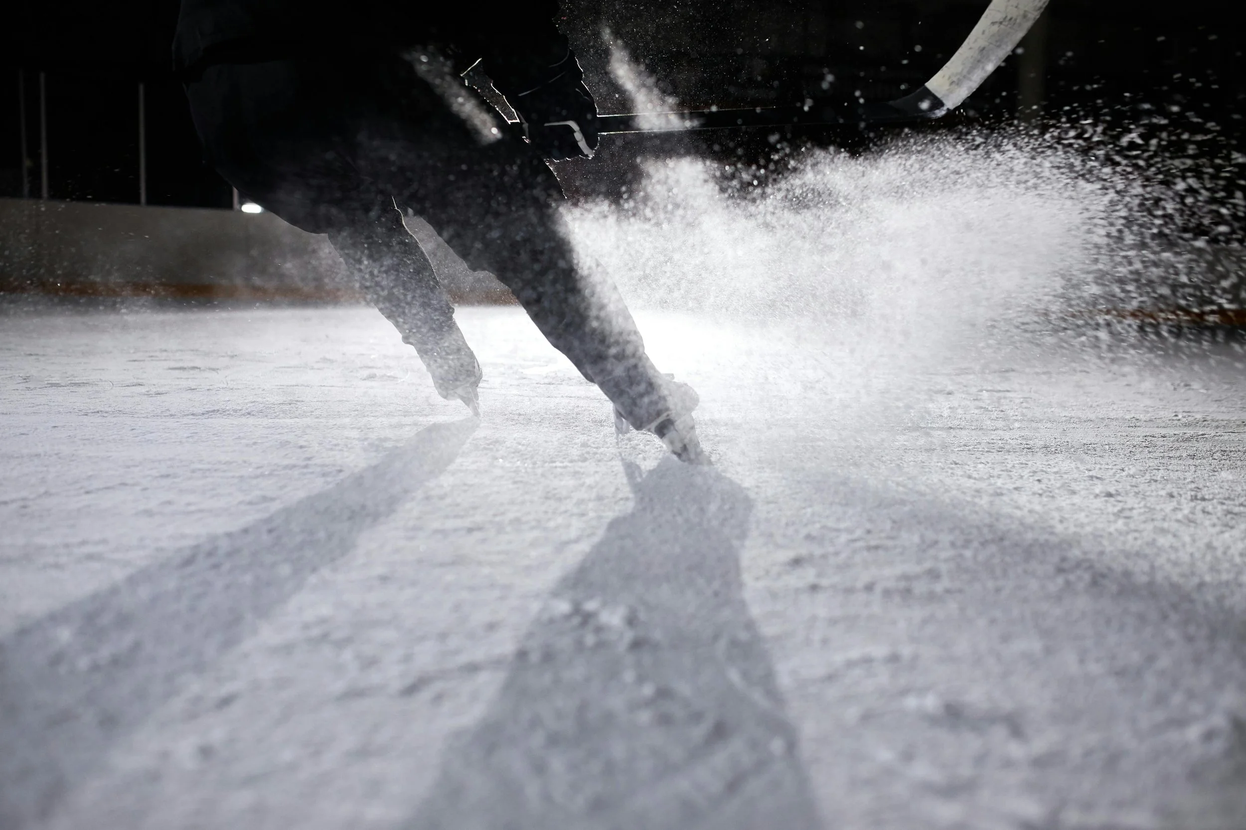 Hockey player falling on ice during game at night