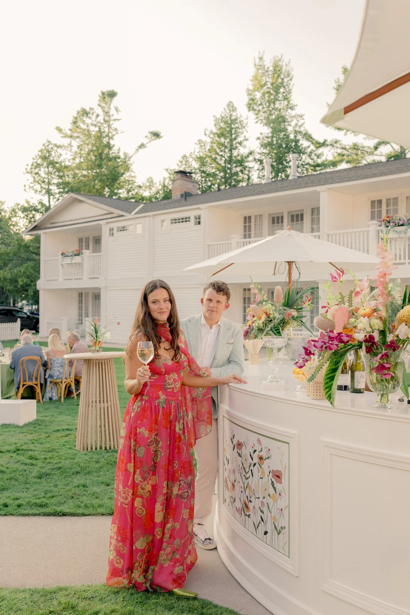 Couple holding a glass of wine and celebrating at their wedding welcome party