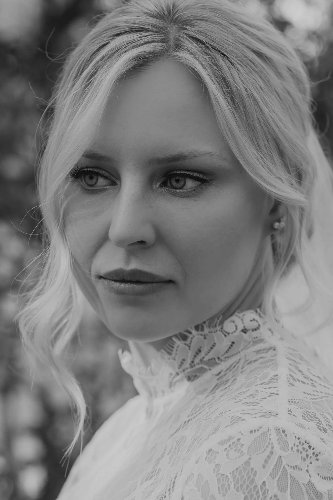 Black-and-white bridal closeup capturing an elegant, dreamy, and timeless moment