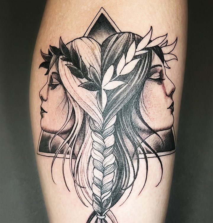 Tattoo of two women's profiles facing opposite directions, connected by a braided hair and adorned with leaves, within a rectangular frame. Adam Guy Hays Denver artist tattoo Hand of Fate