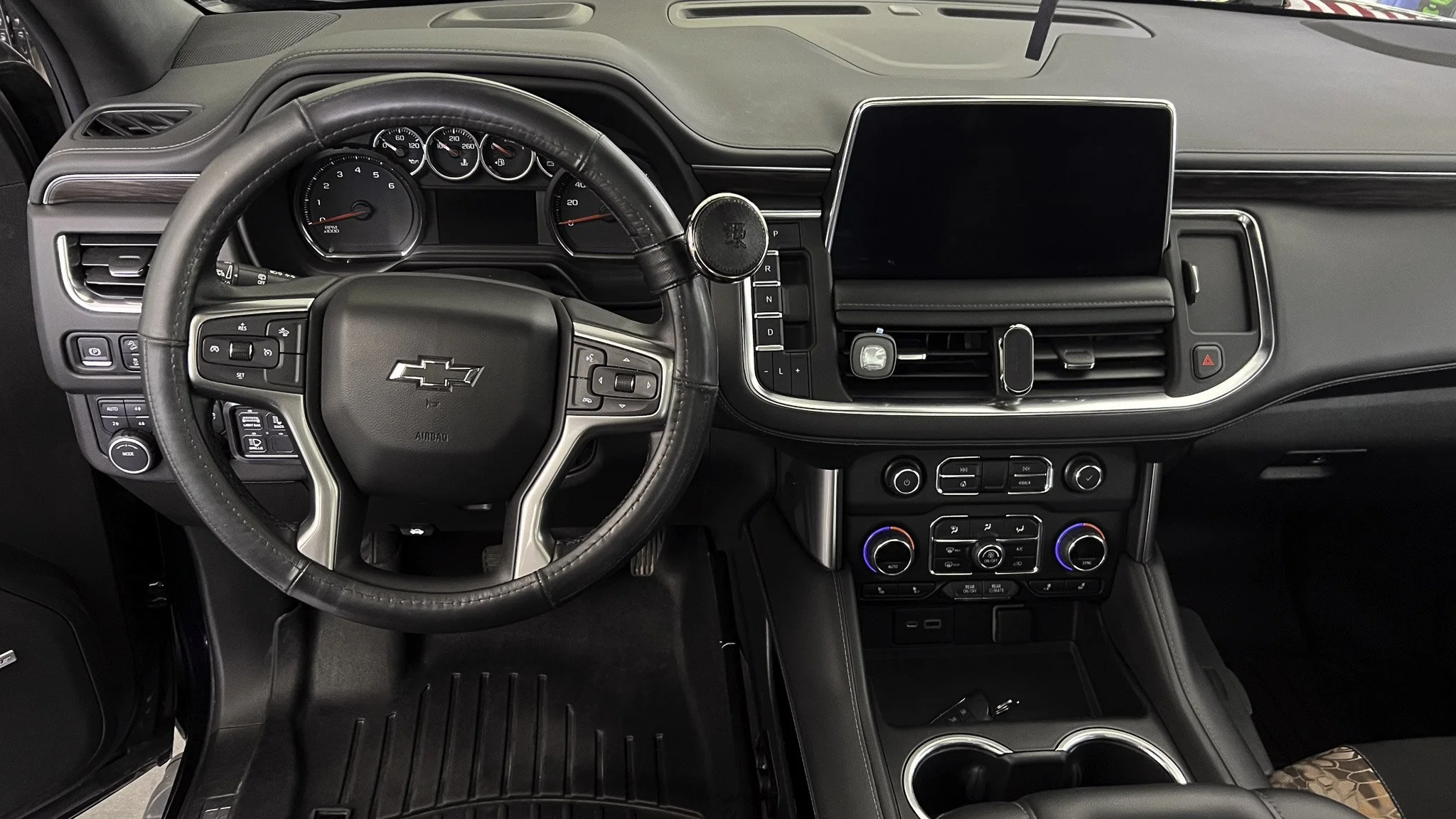 Interior of a Chevrolet vehicle showing the dashboard, steering wheel, and center console with digital display and controls.