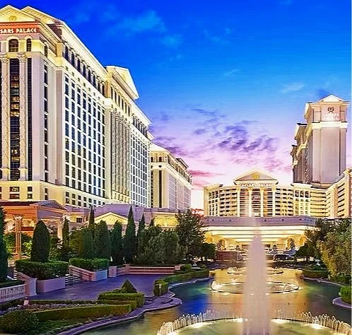 The Bellagio hotel and casino in Las Vegas at sunset, with a fountain in the foreground and luxury buildings in the background.