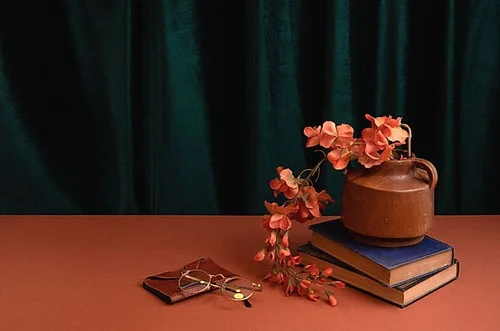 Ceramic teapot, books and eyeglasses still life