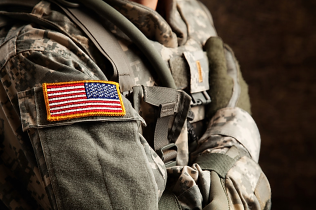 Close-up of a military soldier's uniform with an American flag patch on the shoulder.