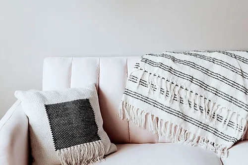 White sofa with a striped throw