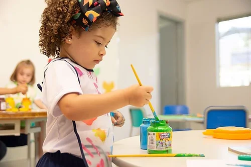 Young girl painting in a classroom