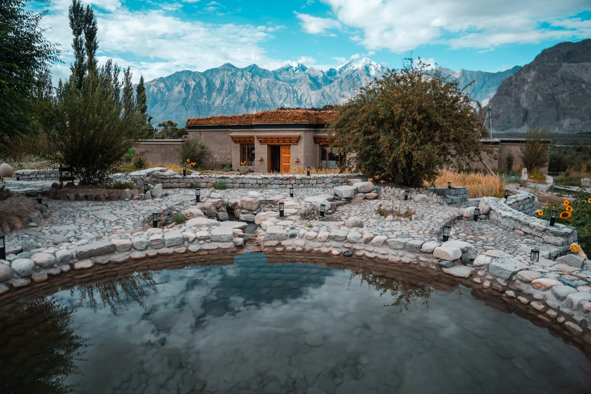 Six young adults in colorful streetwear poses against a blue background, dancing or performing a choreographed move.