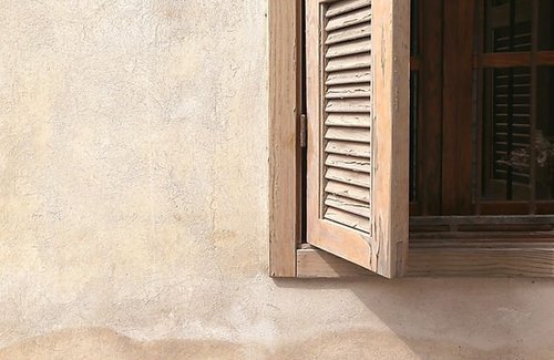 Wooden window shutters on a stucco wall
