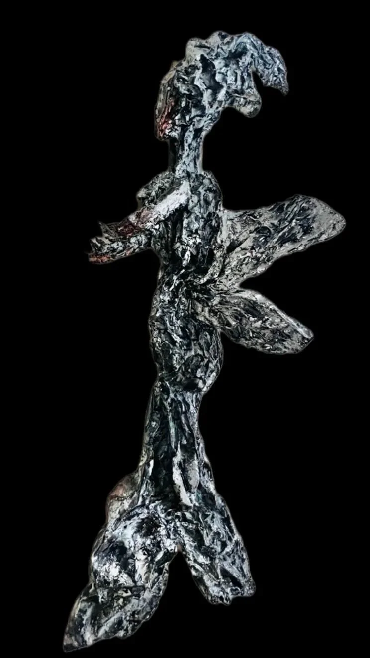 A sculpture of a woman, abstract in style with a marbled black and white surface, set against a black background.