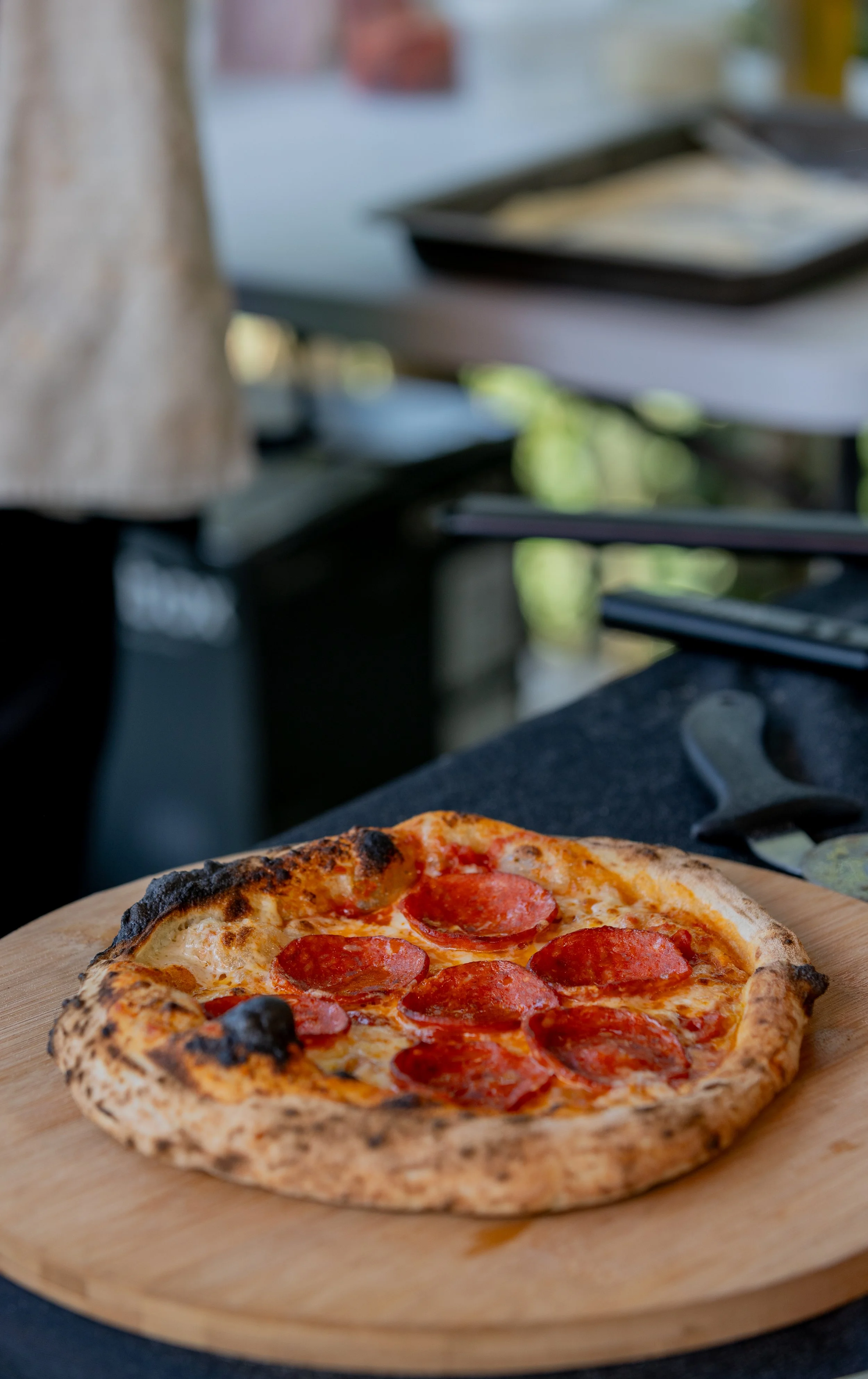 Pizza con pepperoni sobre una tabla de madera