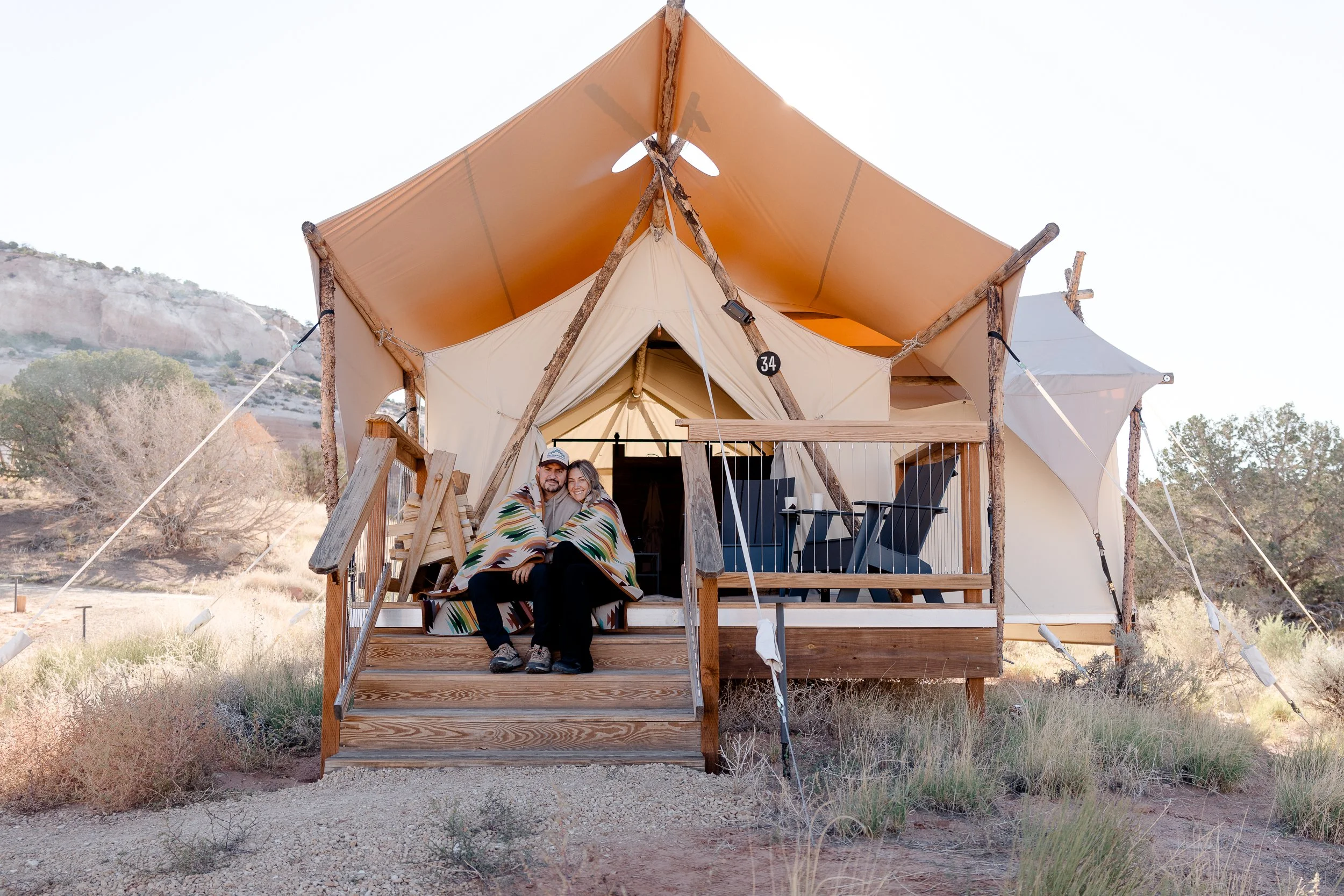 Couple snuggles together at tent at Ulum Resort in Moab.