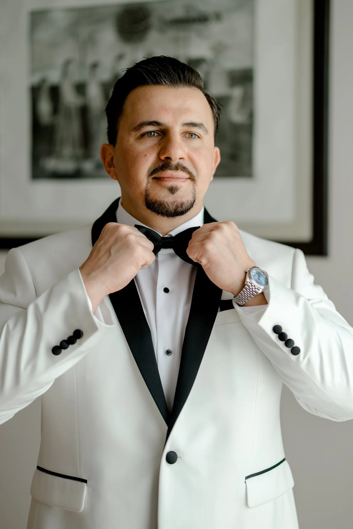 Groom Fixing Bow Tie while Getting Ready.