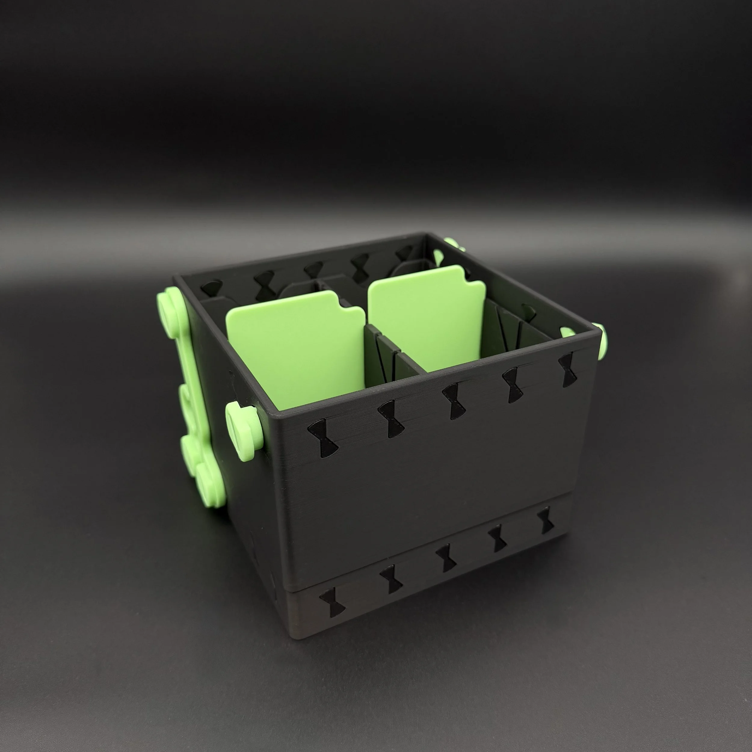 A black and green deckbox shown with it's space saving lid folded underneath it.