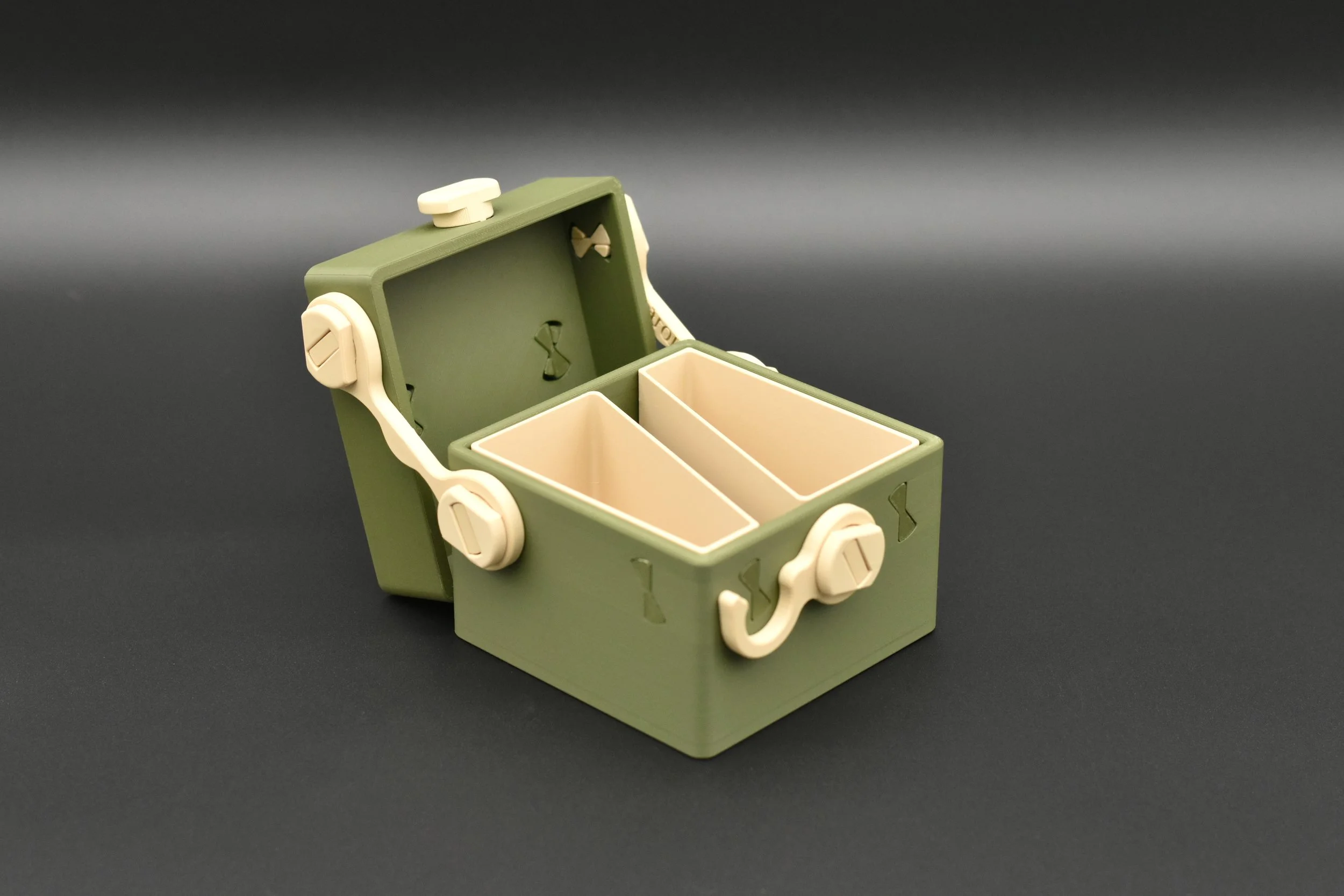An open Token Box in Green and Tan, revealing the internal compartments designed to organize token cards, dice, and counters.