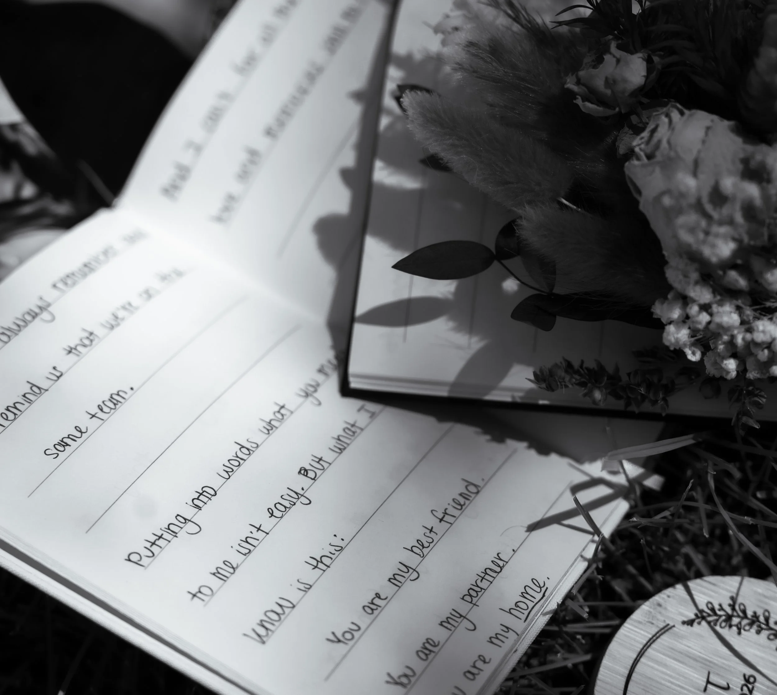 A handwritten letter on lined paper surrounded by flowers and greenery, with some blurry text at the top of the page.