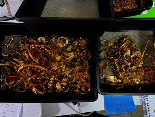 A bucket of mixed precious metal scrap including tangled gold chains and sterling silver flatware pieces in Scranton.