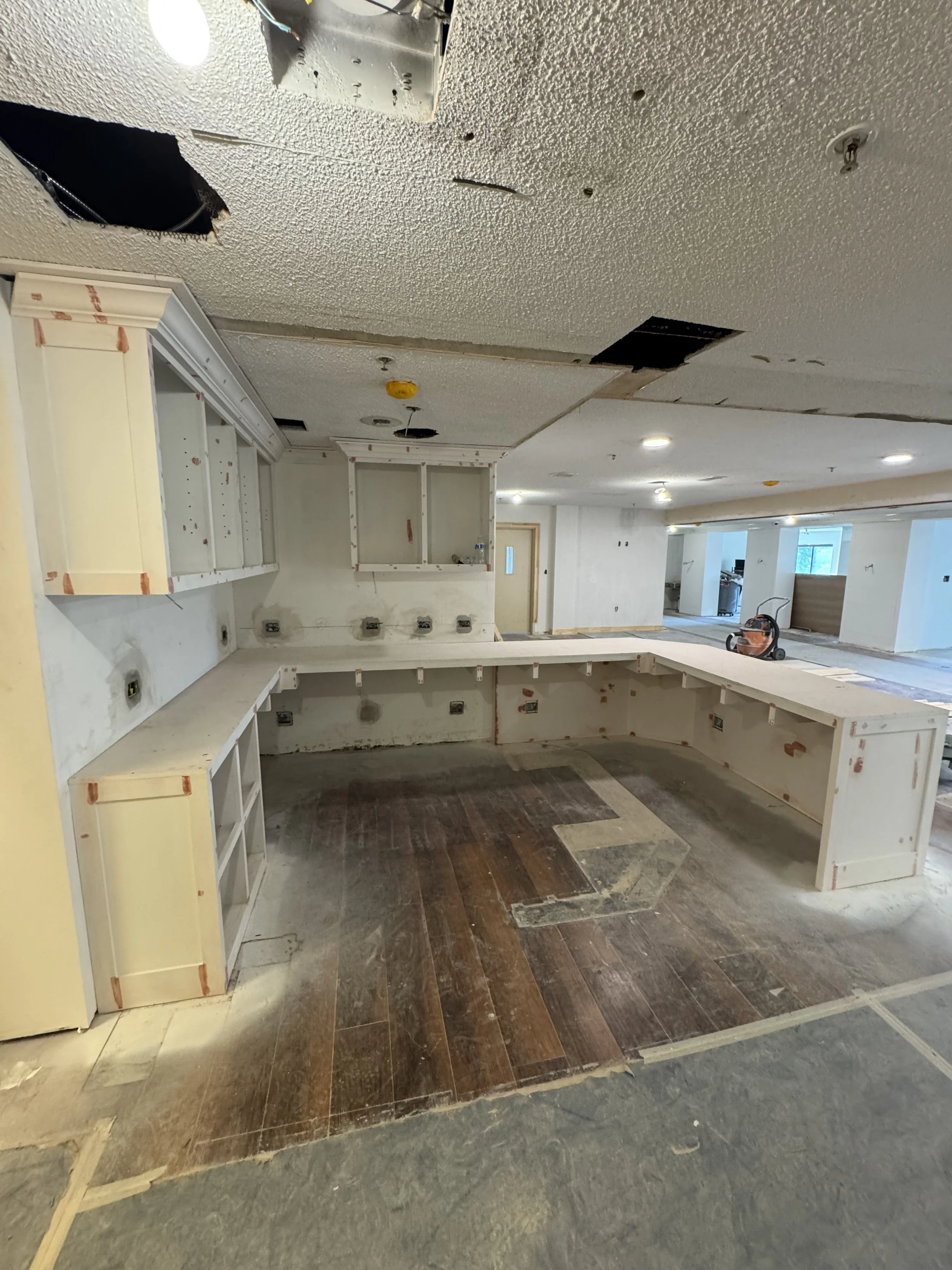 Undergoing kitchen renovation with partially installed cabinetry, exposed wiring, and flooring in progress.