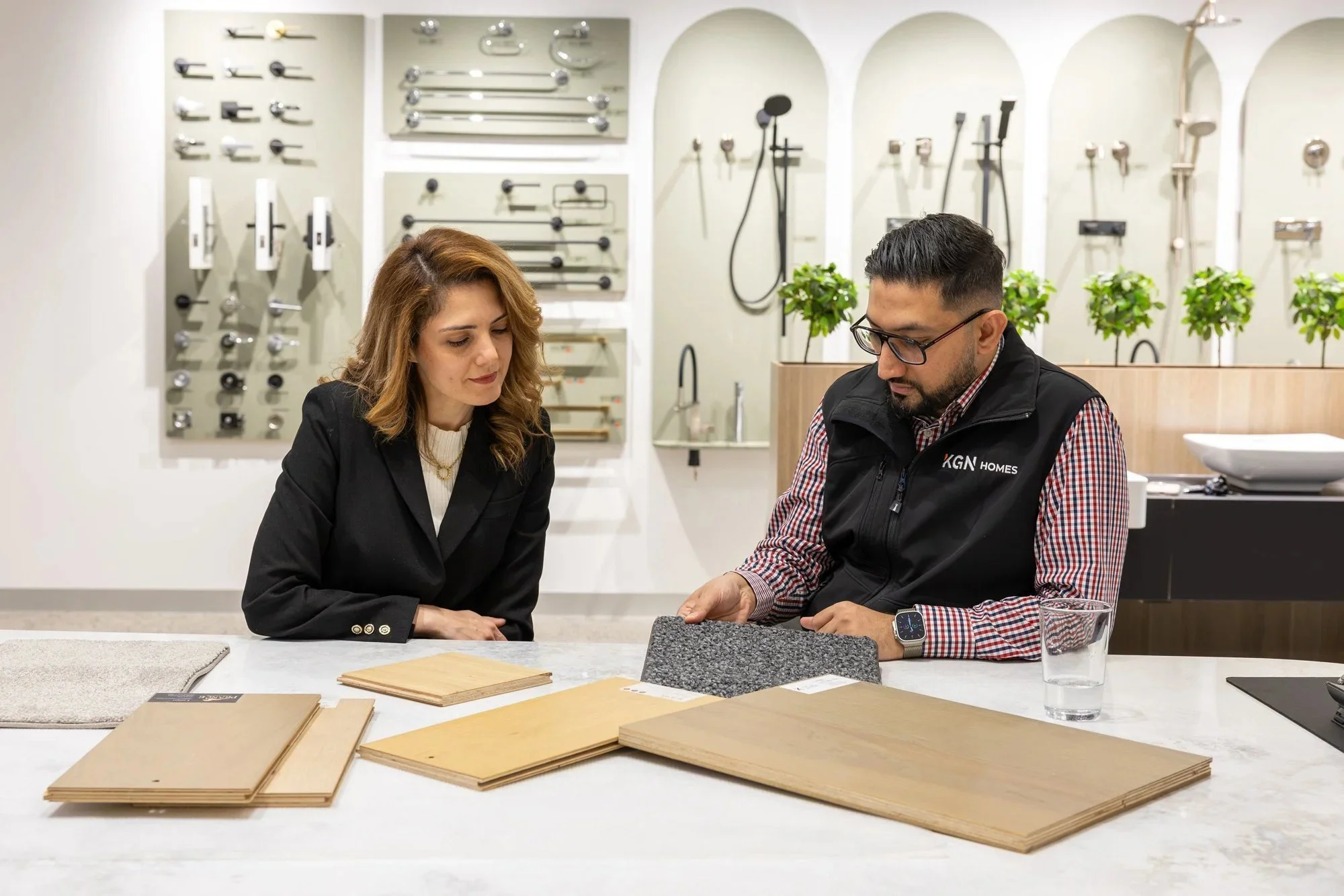KGN Homes interior designer reviewing material samples with clients at K Studio