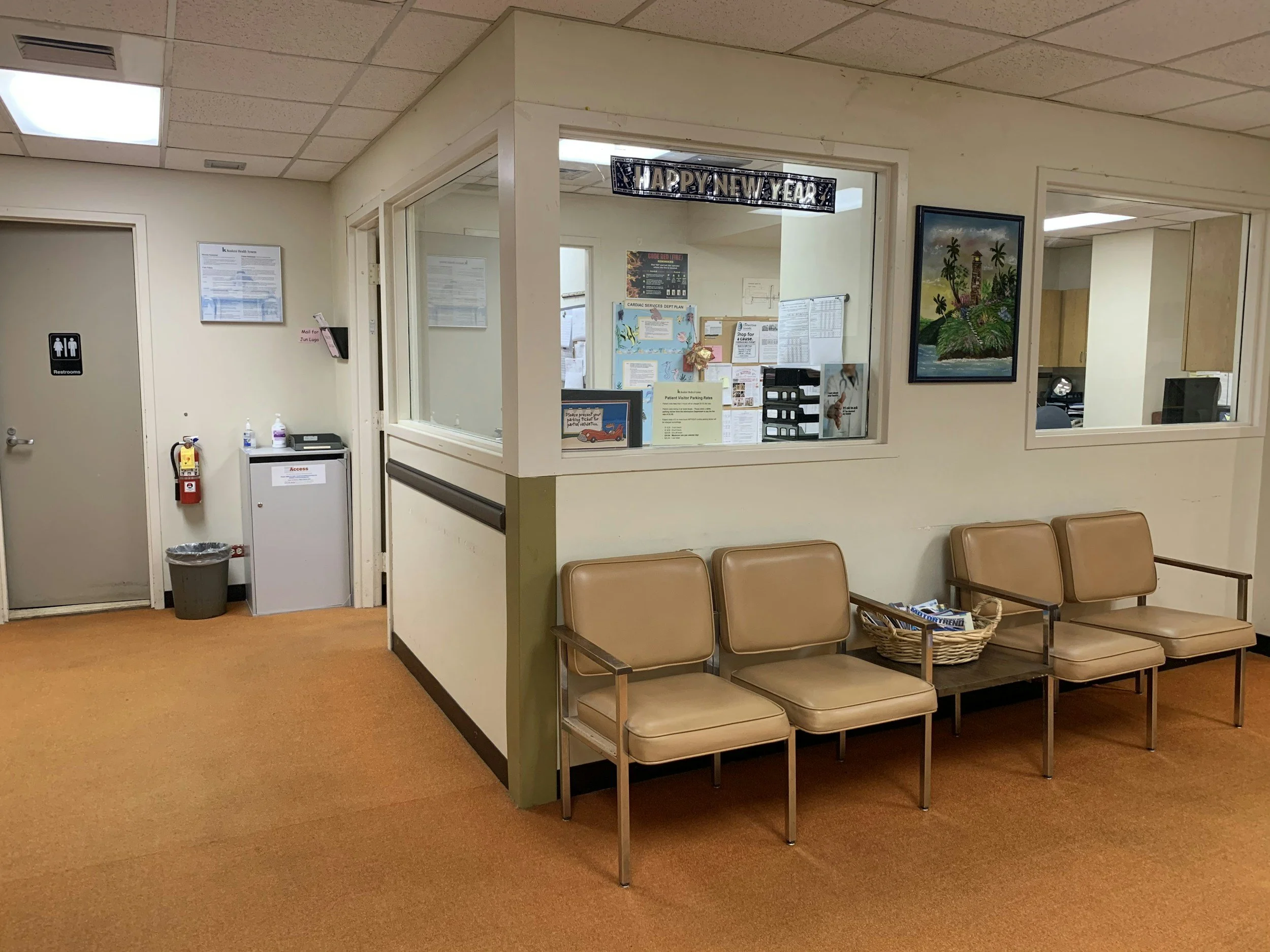 Medical office reception and waiting area with chairs and front desk window.