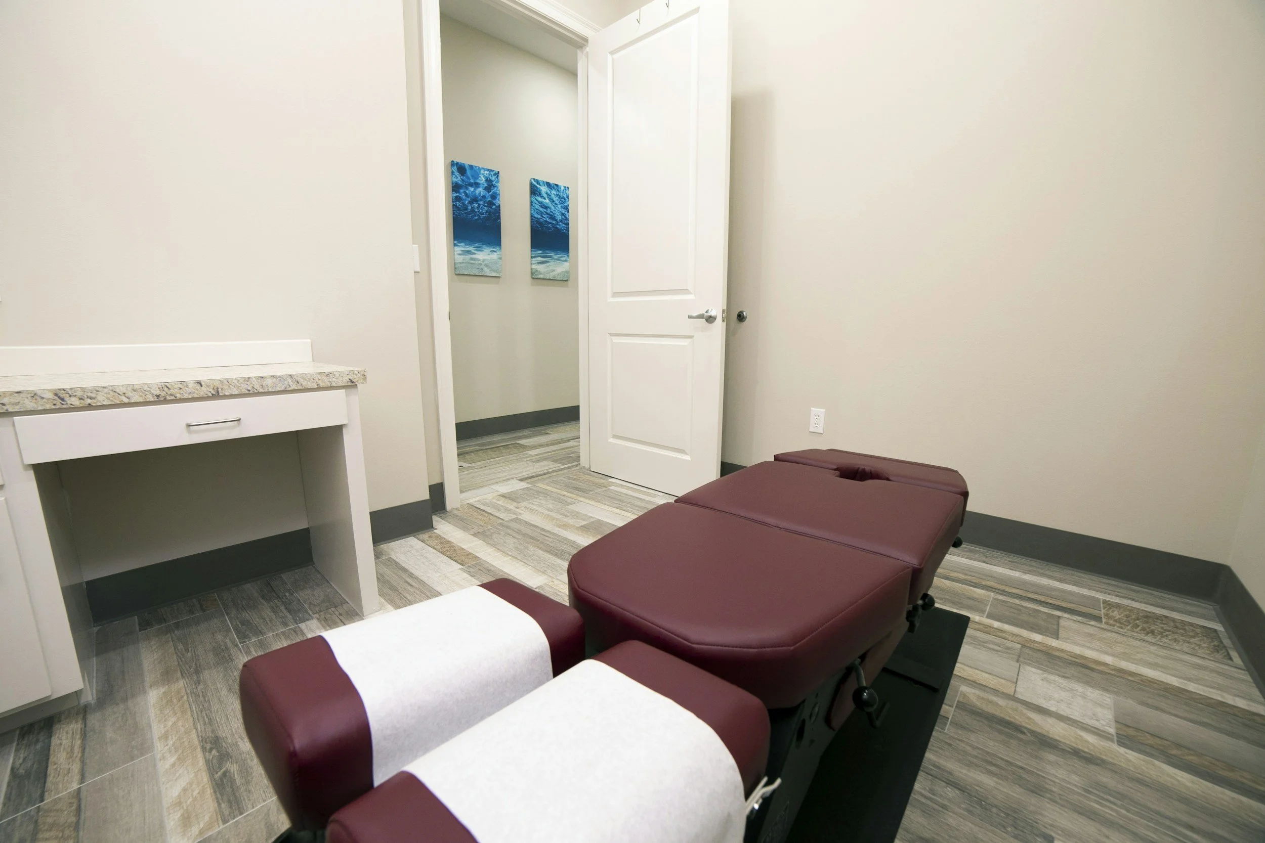 Clean therapy treatment room with padded table used for massage or physical therapy.