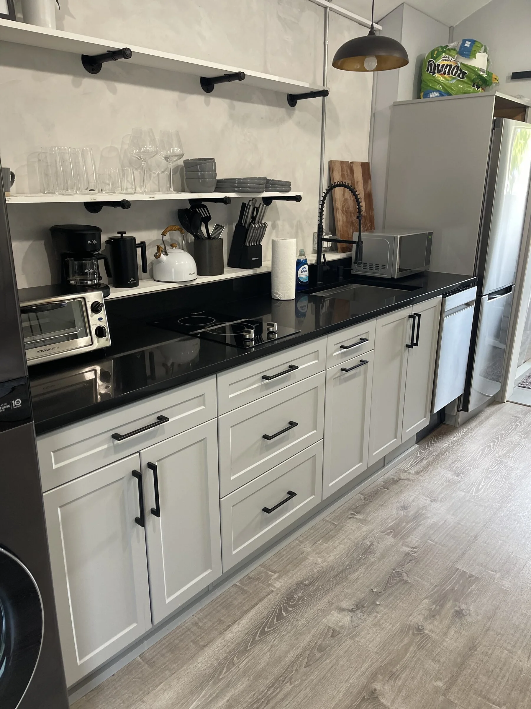 Clean Airbnb kitchen with organized shelves, spotless counters, appliances, and guest-ready setup