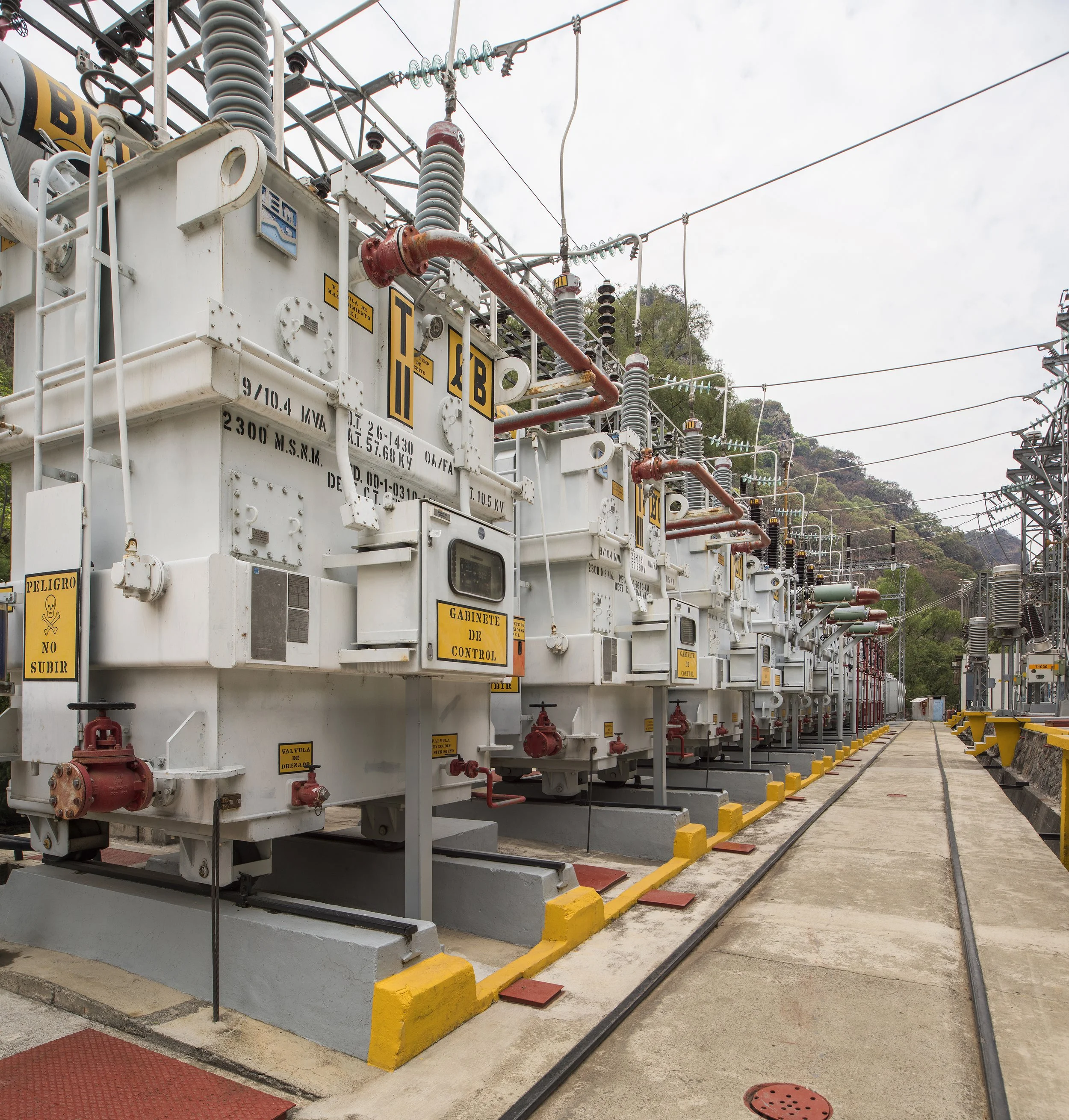 Tuberías metálicas de gran diámetro conectadas a una estructura de concreto, probablemente parte de una central hidroeléctrica o infraestructura de conducción de agua.