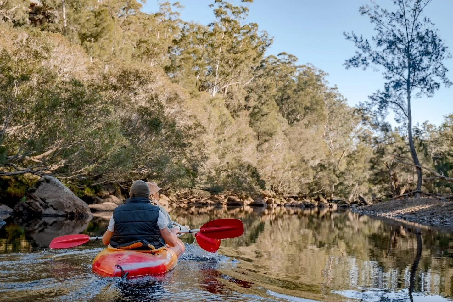 Two people on a kayak adventure on a serene river in the forests of Kangaroo Valley