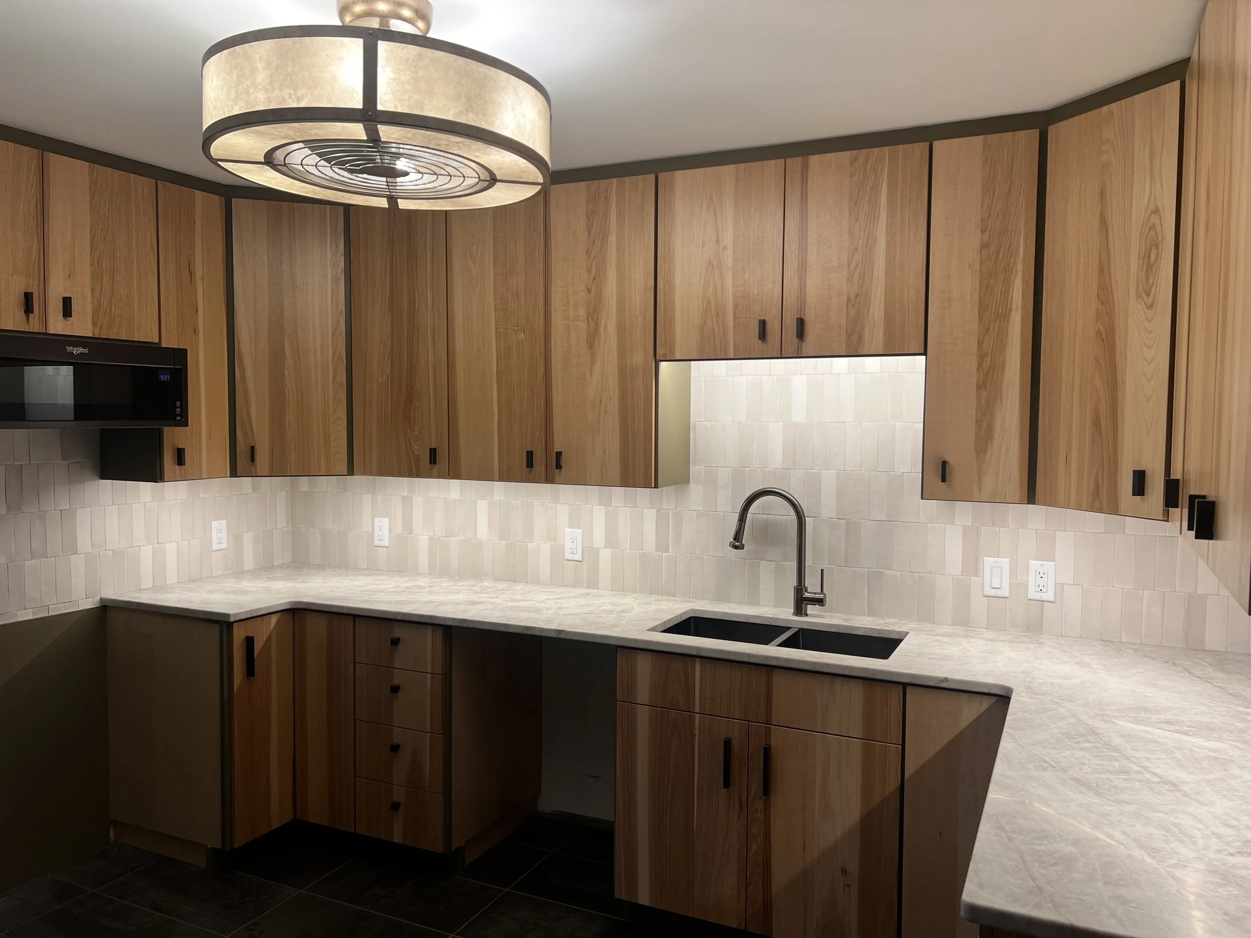 A modern kitchen remodel with new electrical work done by Walter Electrical Contractors, featuring updated lighting, under cabinet lighting, and appliance-ready outlets.