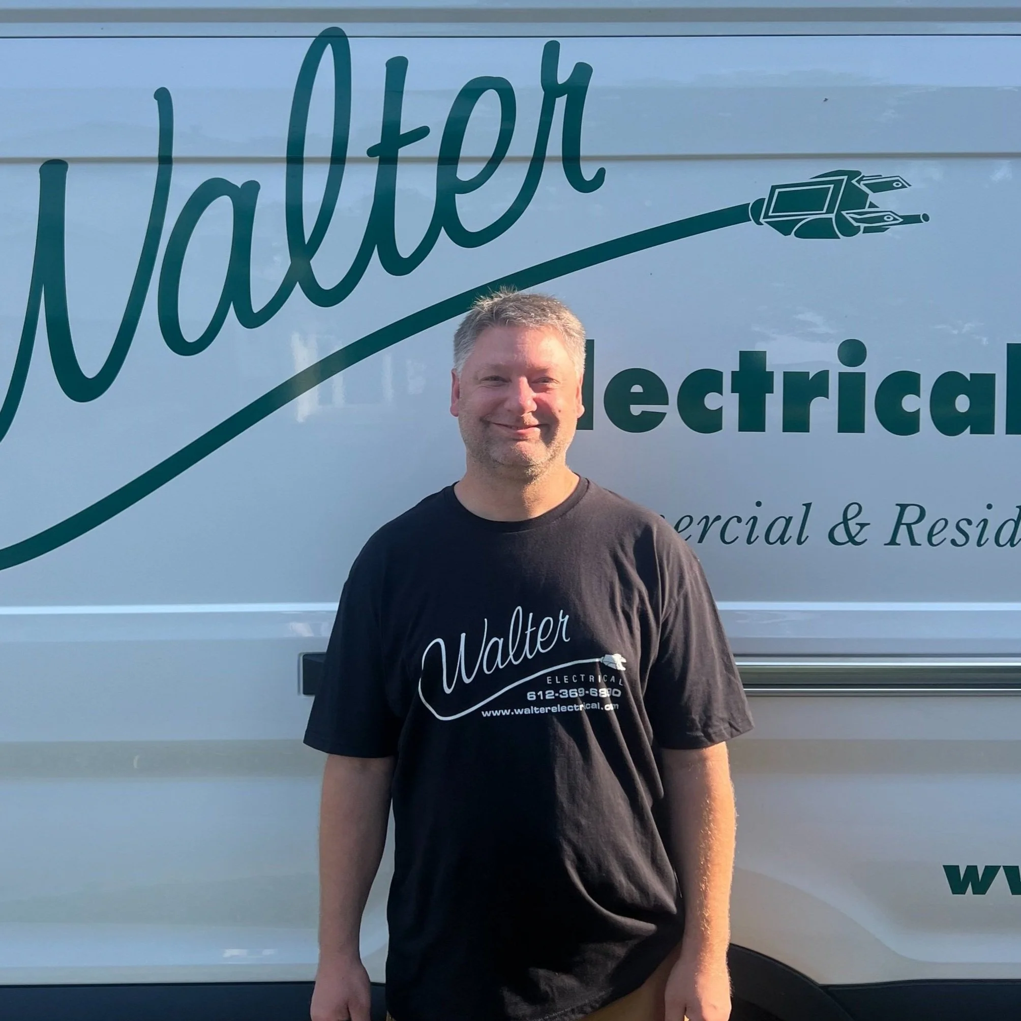 Walter Electrical Contractors estimator and licensed electrician standing in front of branded company van, serving Twin Cities residential and commercial clients.