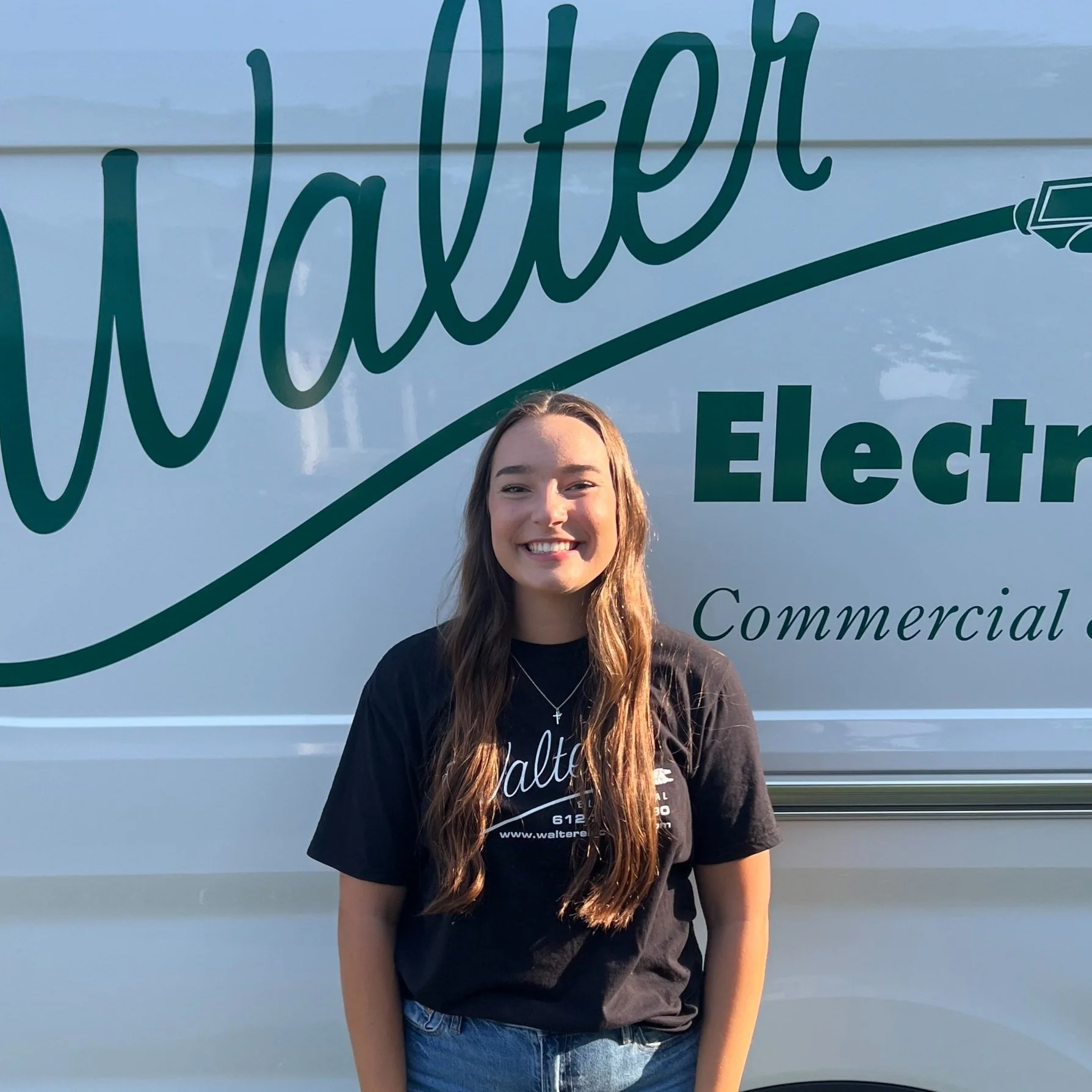Walter Electrical Contractors office assistant standing in front of branded company van, serving Twin Cities residential and commercial clients.