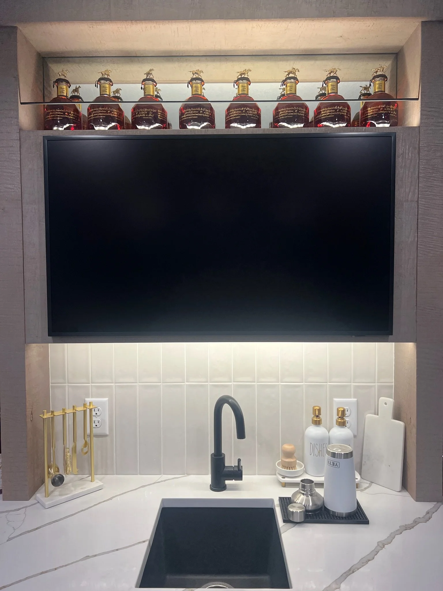 Kitchen bar area with under-cabinet lighting, decorative shelf lighting, and power setup for mounted monitor, all installed by Walter Electrical Contractors in Minnesota.