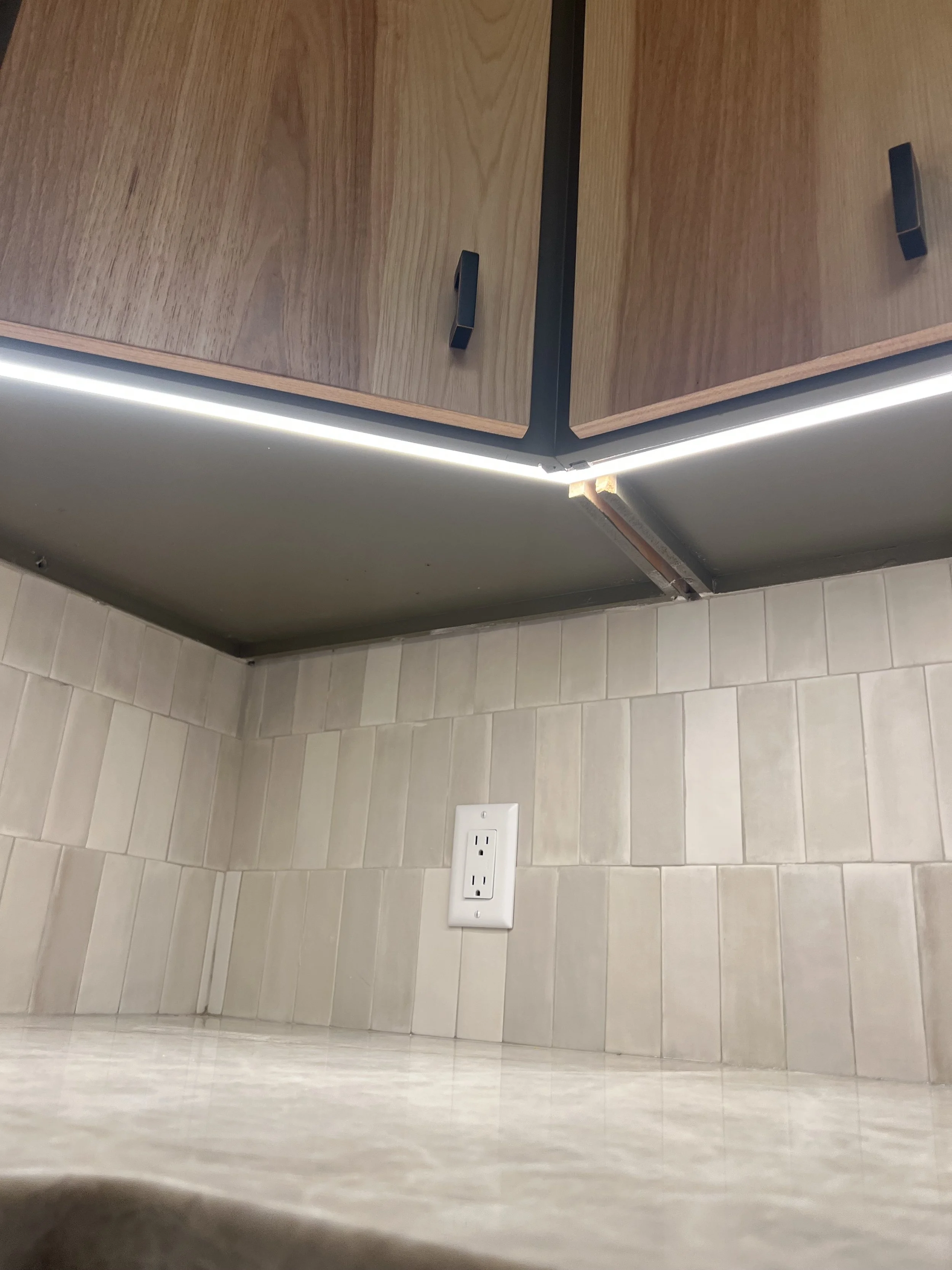 Under cabinet lighting in a modern kitchen remodel installed by Walter Electrical Contractors.