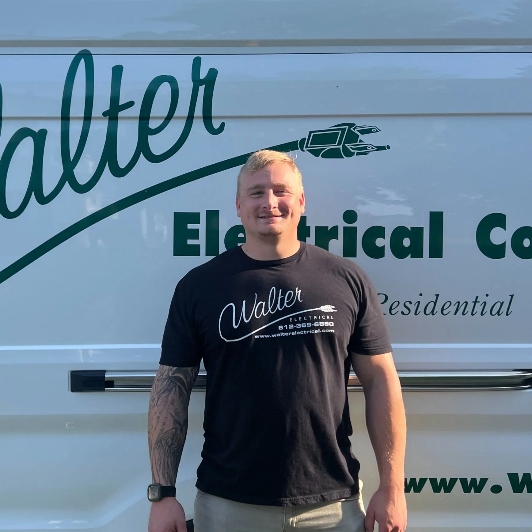 Walter Electrical Contractors owner Riley Johnson a licensed journeyman electrician standing in front of branded company van, serving Twin Cities residential and commercial clients.