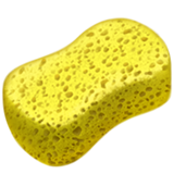 Yellow kitchen sponge with porous surface resting on a purple surface