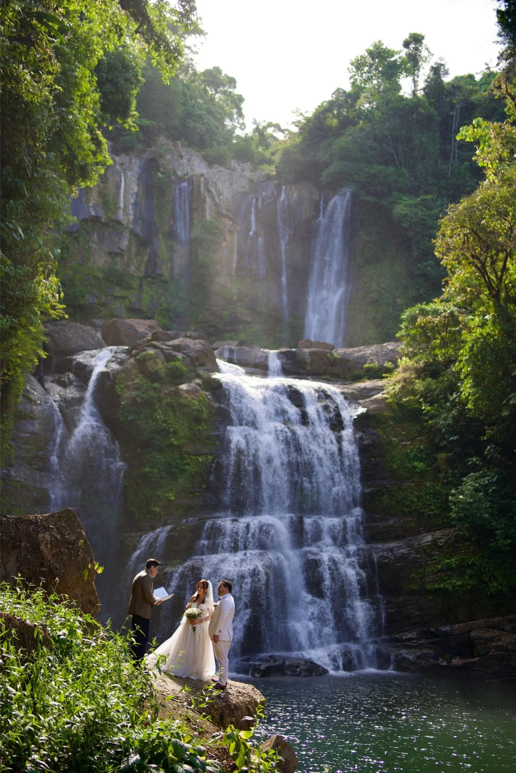 Elopement ceremony at Nauyaca waterfall, Costa Rica, with bride, groom and officiant