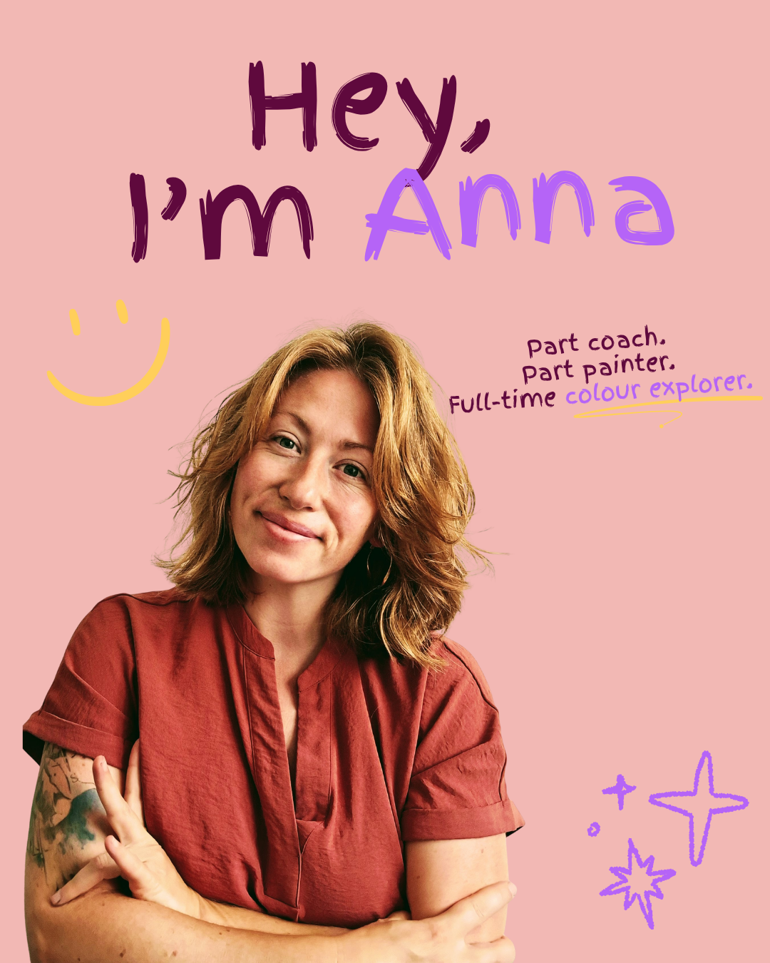 A woman with shoulder-length curly red hair and a tattoo on her left arm, smiling and wearing a reddish-brown shirt, standing in front of a pink background with handwritten text and doodles.