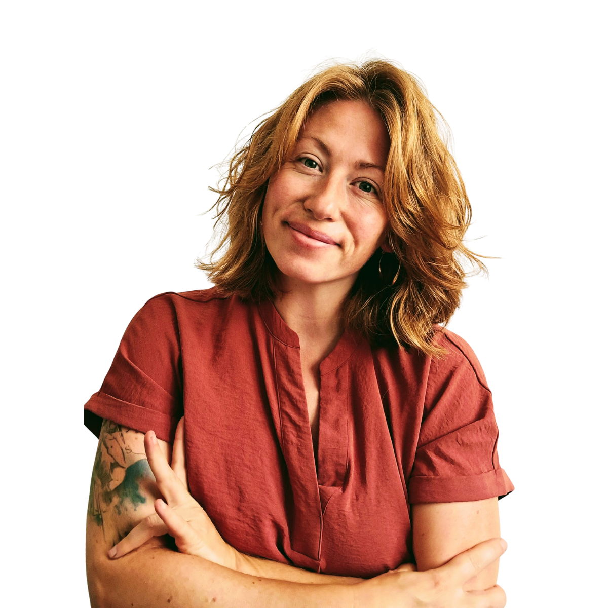 A woman with shoulder-length wavy hair, wearing a red shirt, smiling, and crossing her arms.