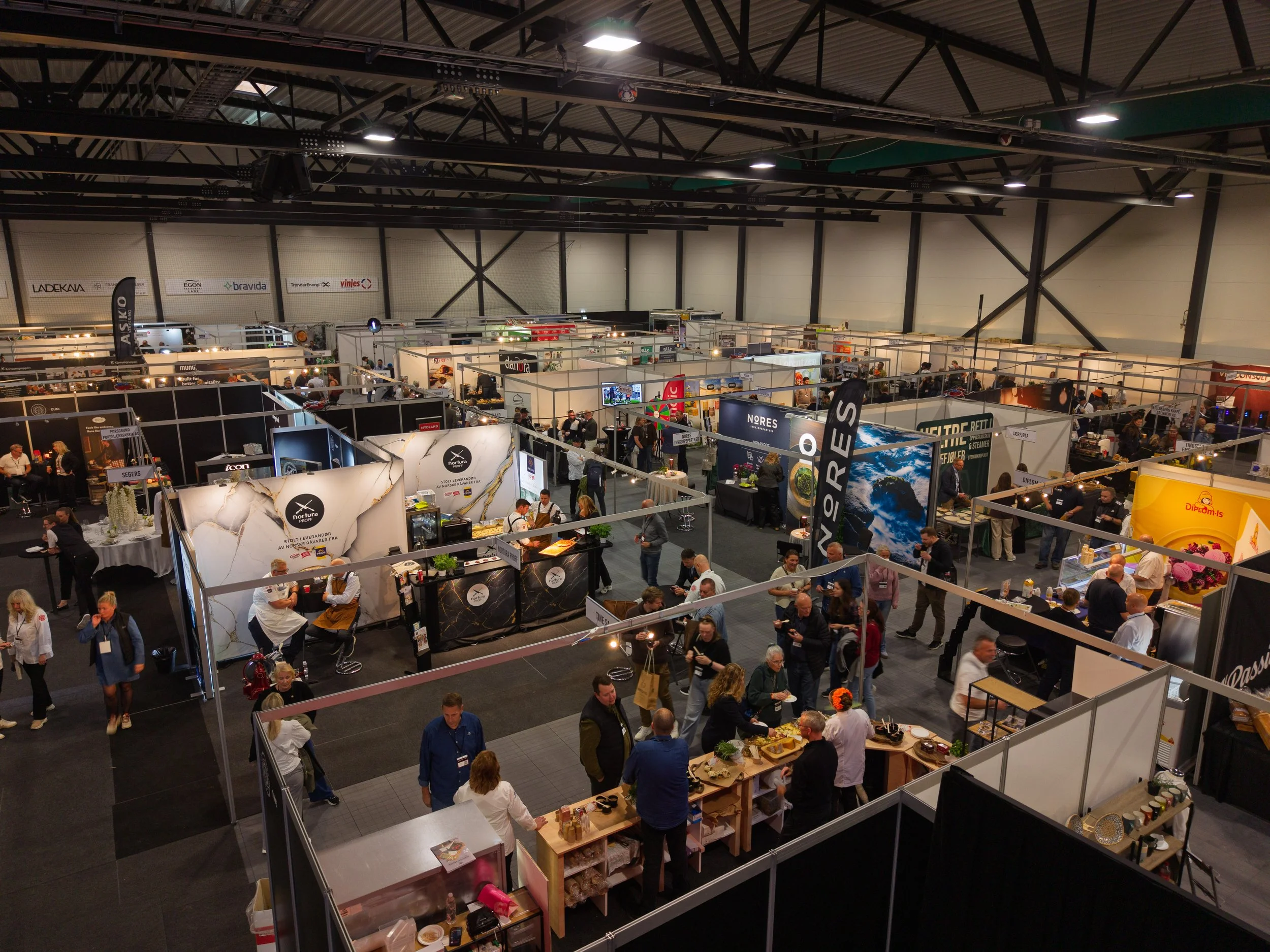 Oversiktsbilde av messen under NM i kokkekunst og NM i servitørfaget 2026 i Trondheim, med utstillere og besøkende i hallen.