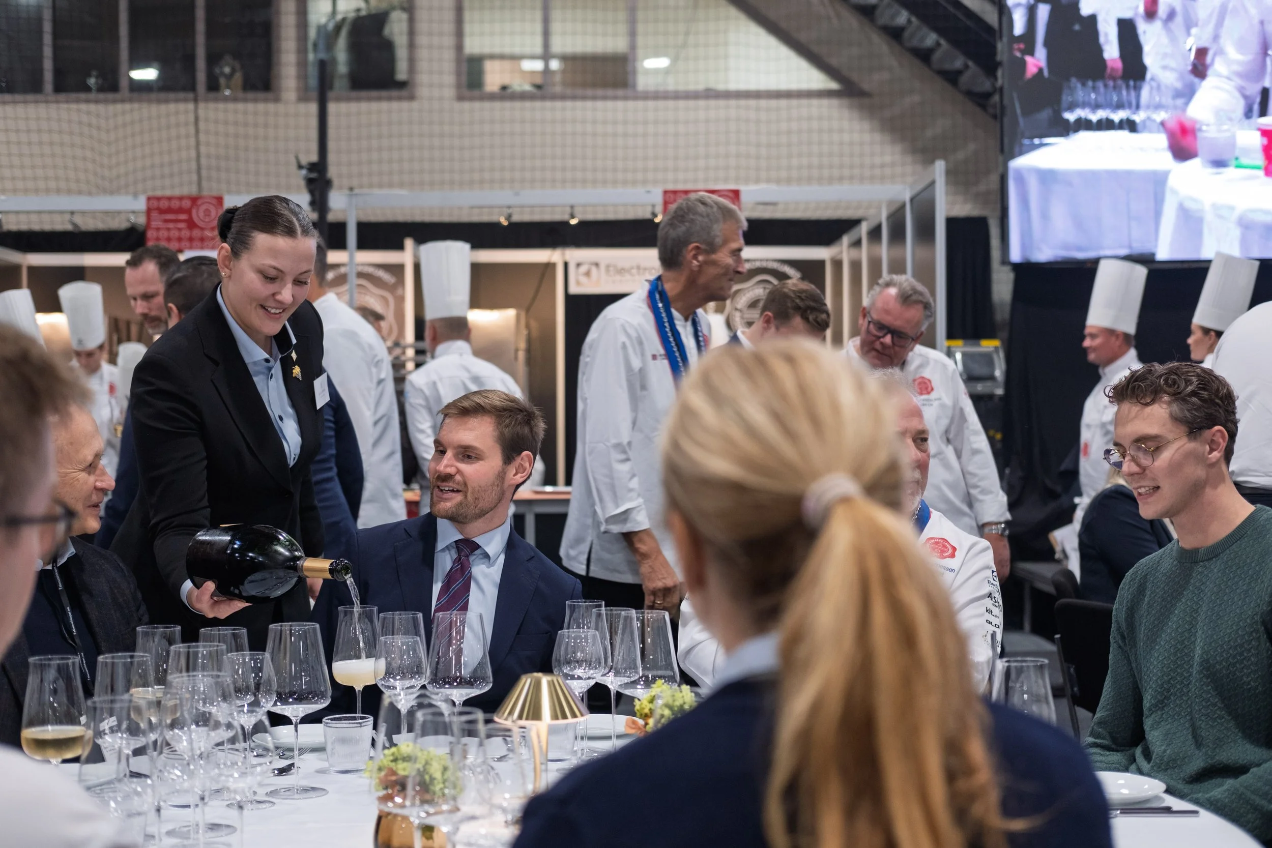 Vilde Sandnes, vinner av NM i servitørfaget 2026, serverer landbruks- og matminister Nils Kristen Sandtrøen under mesterskapet i Trondheim.