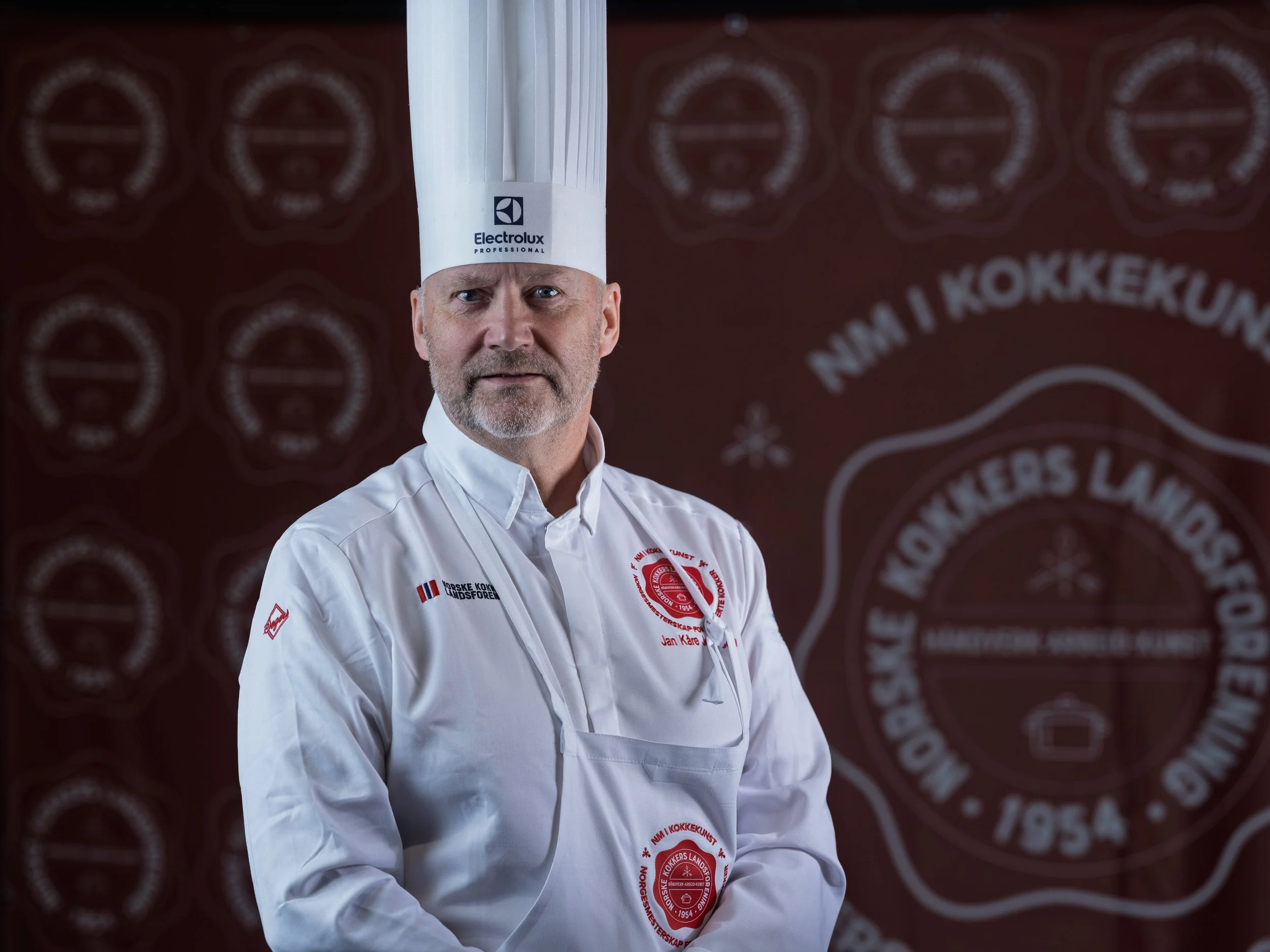 Jan Kåre Johansen, dommer under NM i kokkekunst 2026 i Trondheim, fotografert foran NKLs konkurranseprofil.