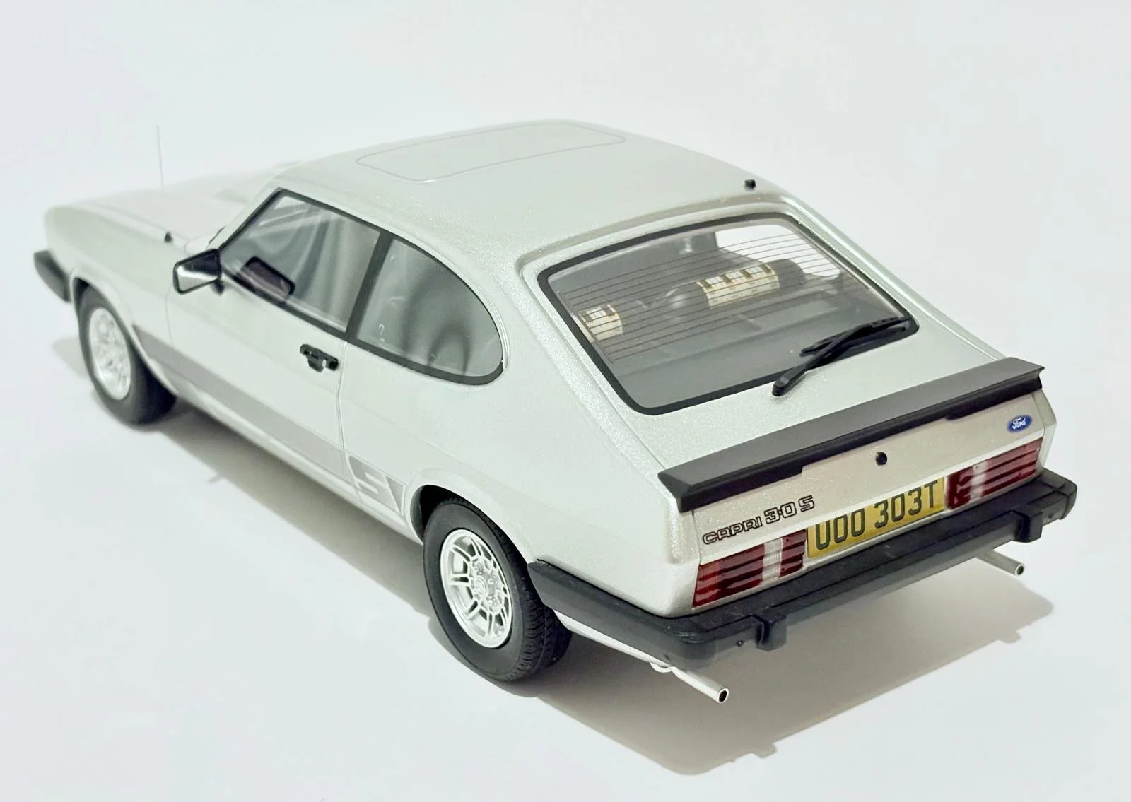 A white model car of a Ford Capri 3.0S viewed from the rear and side.