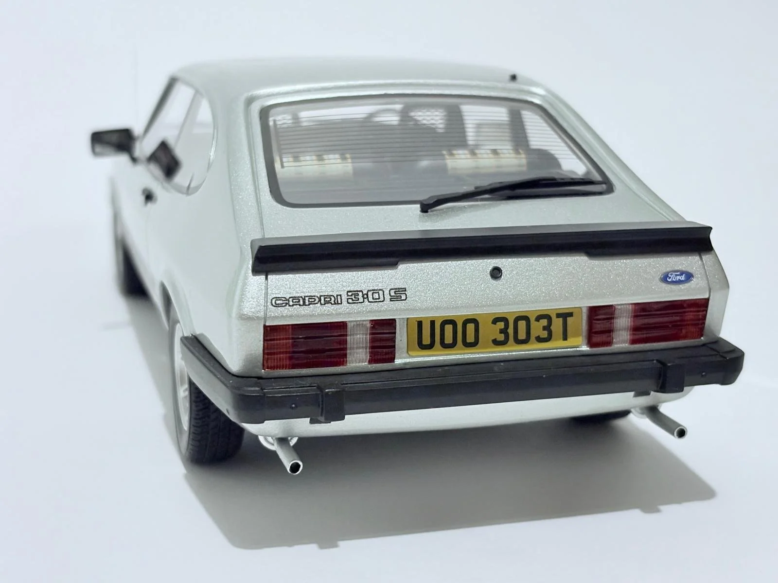Model of a silver Ford Capri 3.0 S car from the rear, with a yellow license plate and dual exhaust pipes.