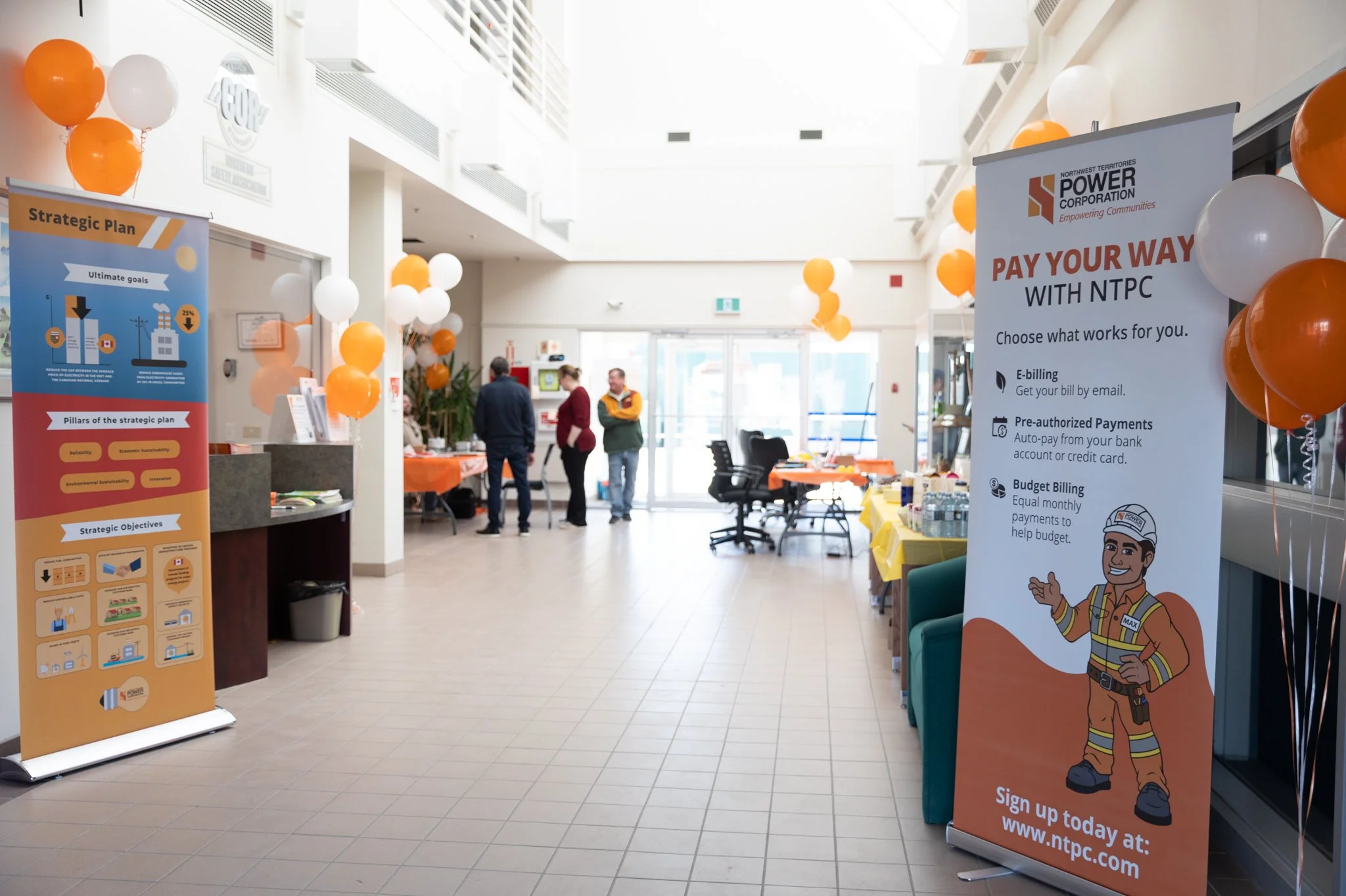 NTPC customer event in Hay River, with information banners and orange and white balloons