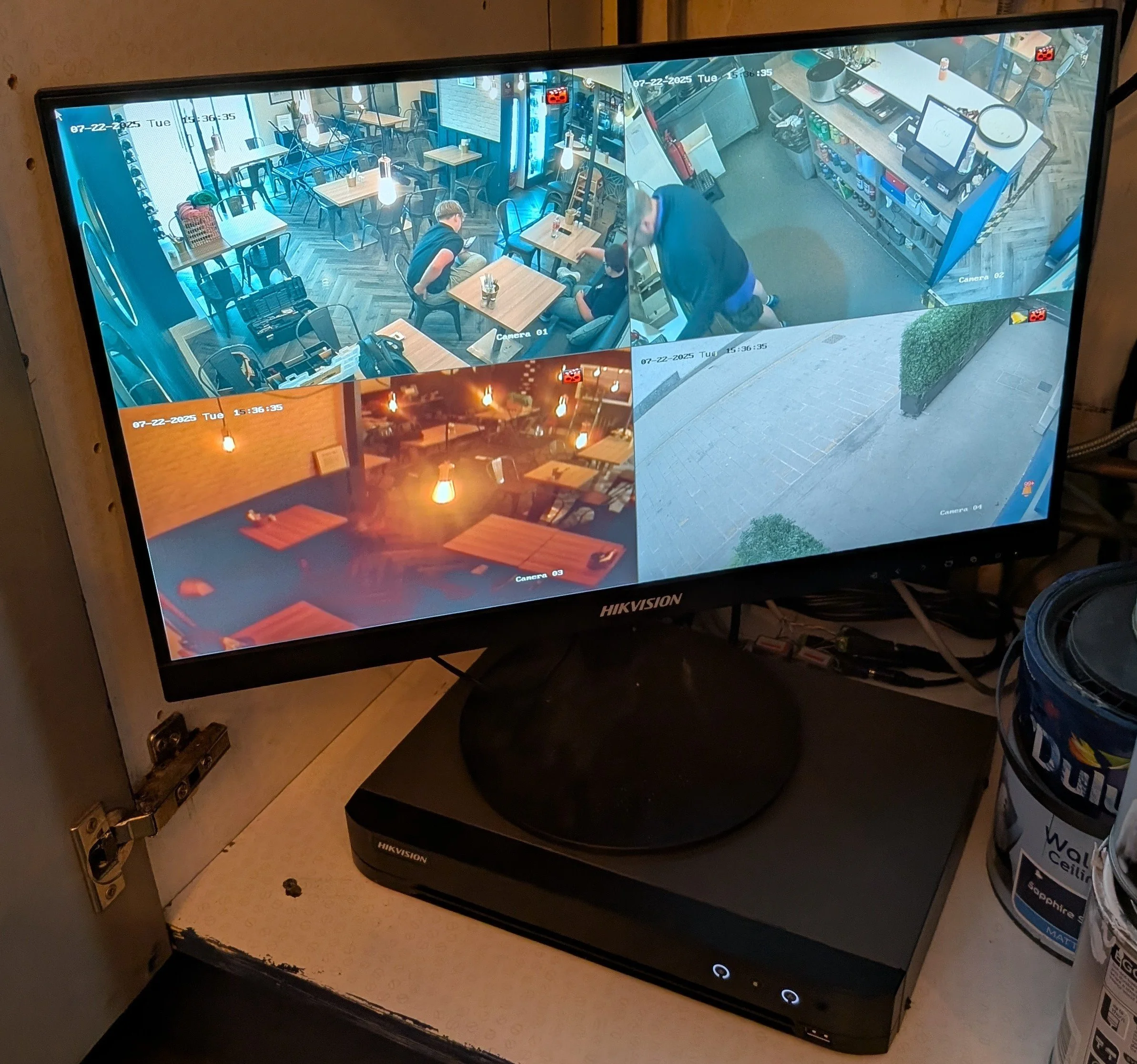 CCTV Security: Surveillance monitor displaying four camera feeds from a restaurant and outdoor area - Carrickfergus 