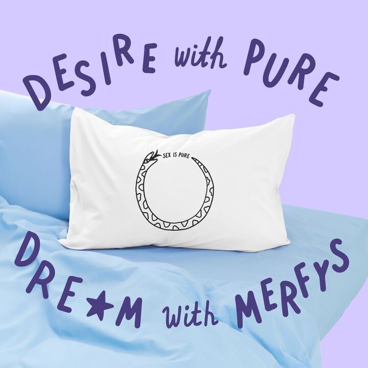 A white pillow with a black outline of a vagina, containing the phrase "Sex is pure" inside, resting on a light blue bed with purple and blue pillows. Overlaid text in purple reads, "Desire with pure Dream with Merfy's".