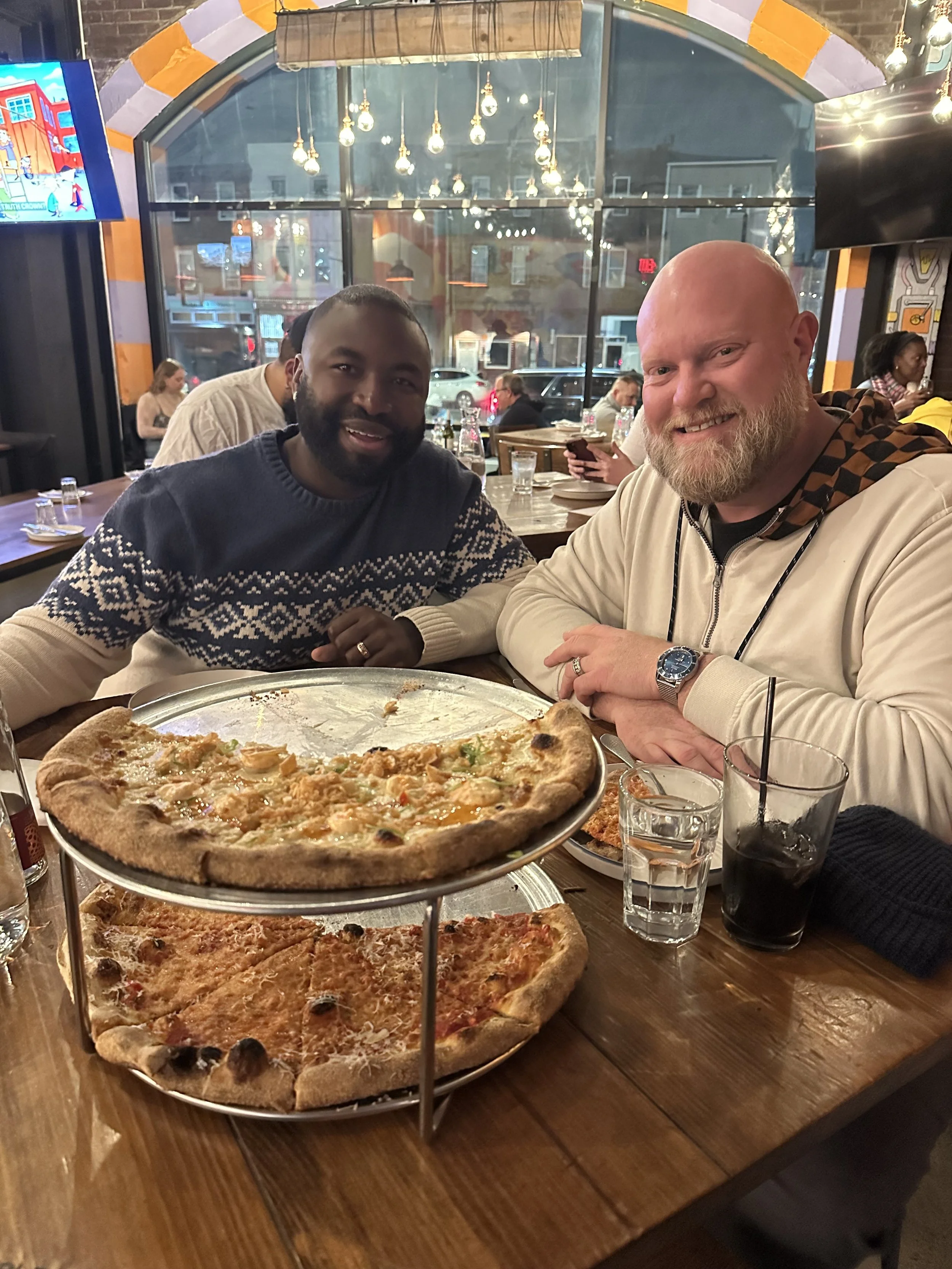 Male couple eating sourdough pizza before underground arts concert
