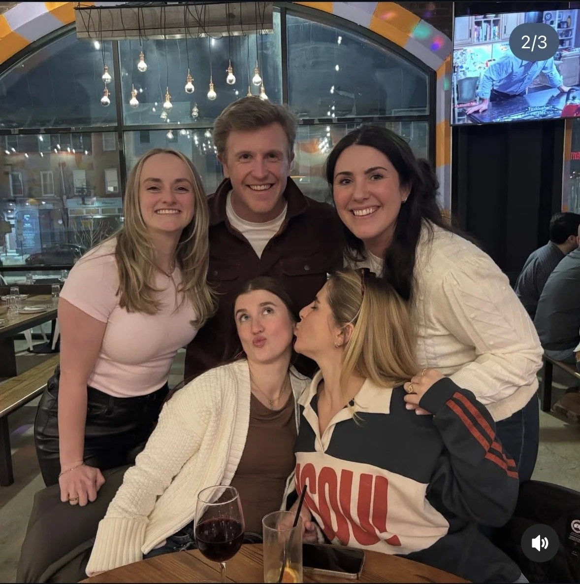 group of 5 friends having fun posing inside in front of big window after playing tuesday night quizzo