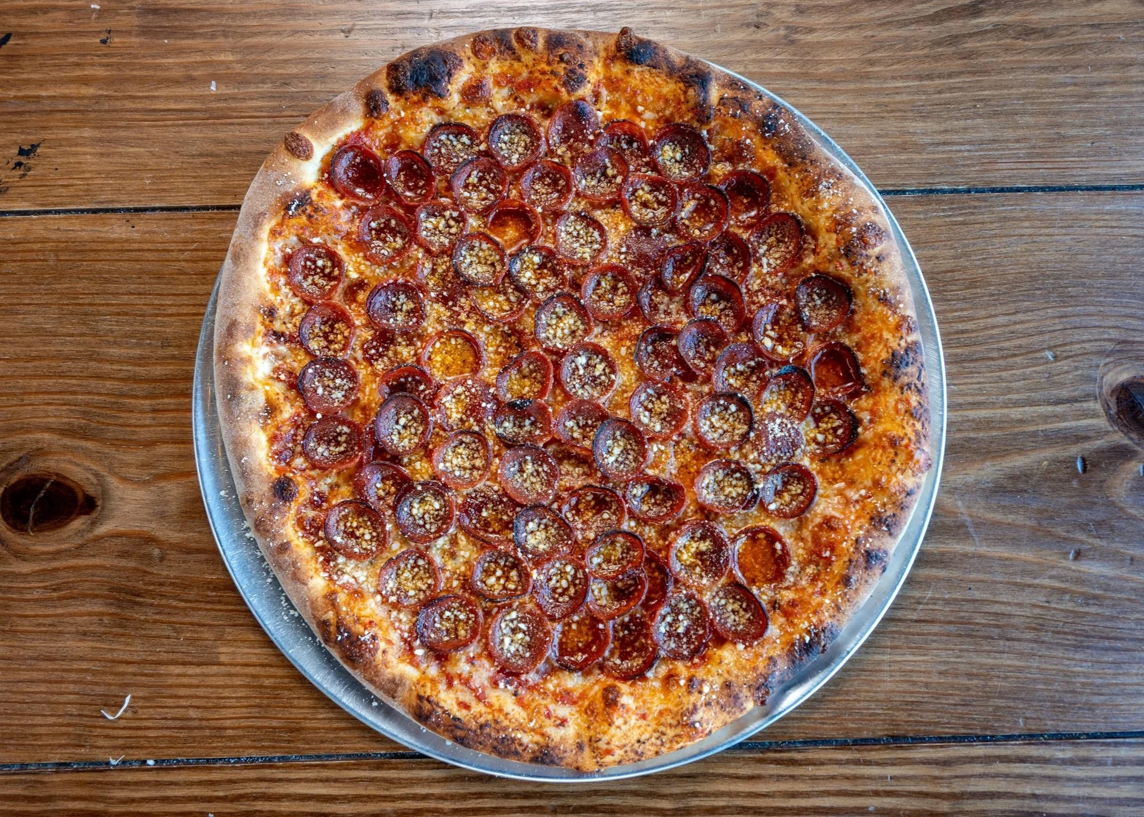 16" pizza pie with cut smoked pepperonis, tomato and basil red sauce base on sourdough crust with mozarella.