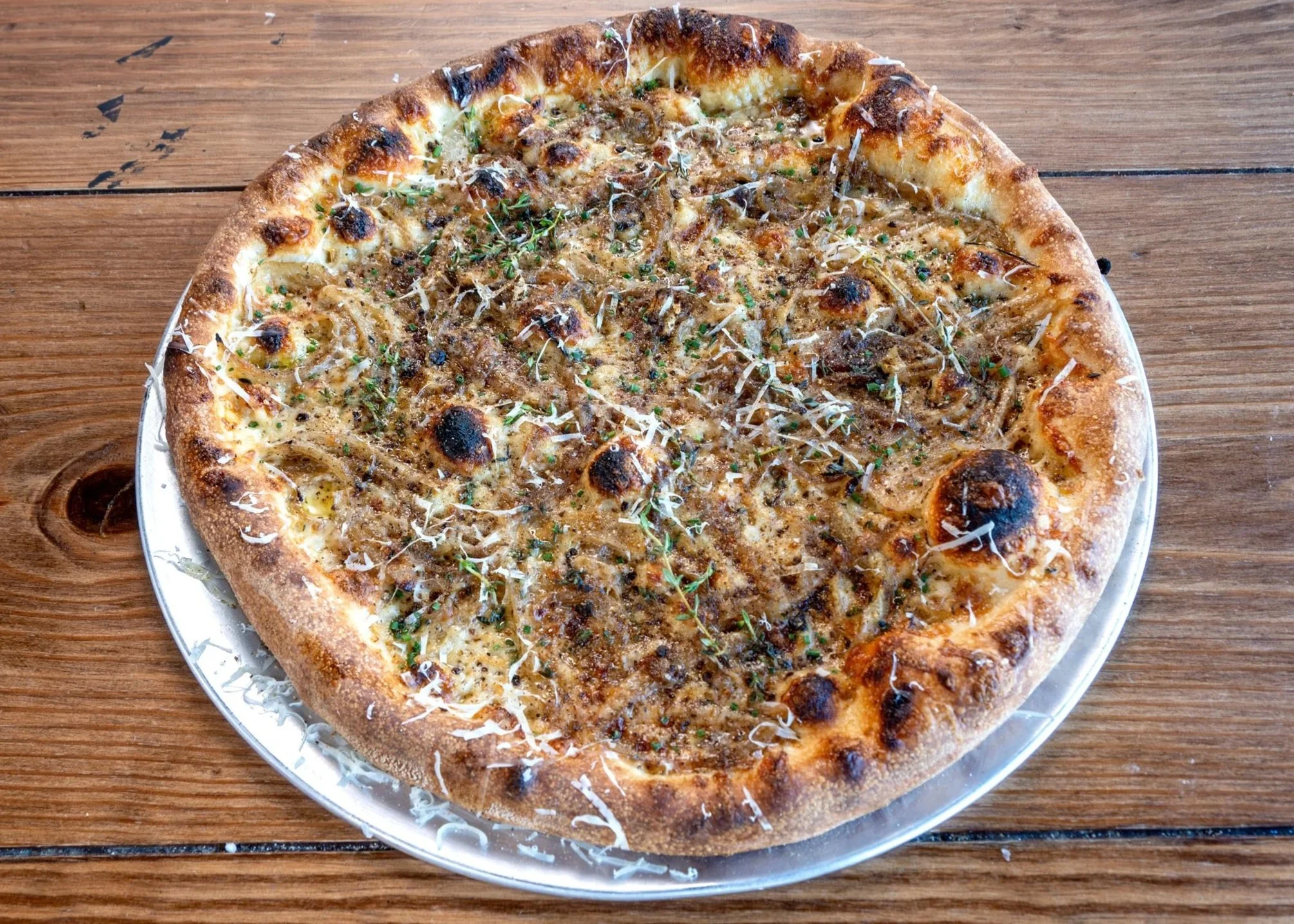 16" pizza pie with caramelized onions fresh thyme, gruyere and pumpernickle crumbleon sourdough crust with mozzarella and house made garlic cream base.